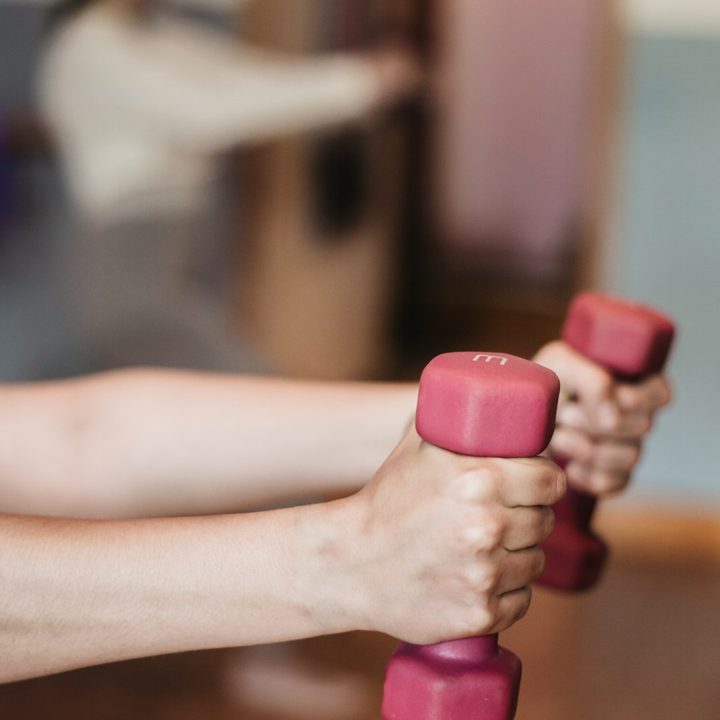 Hands lifting light dumbbells during an exercise session